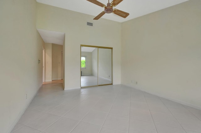 tiled empty room featuring ceiling fan