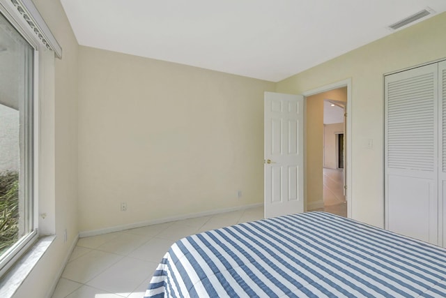 unfurnished bedroom with a closet and light tile patterned floors