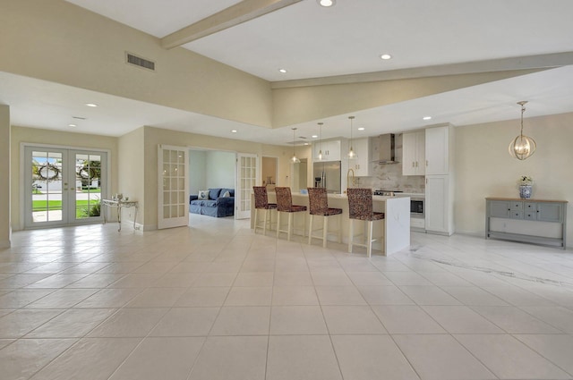 kitchen featuring french doors, decorative light fixtures, a kitchen island, and stainless steel refrigerator with ice dispenser