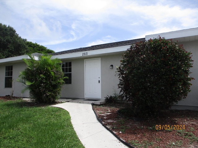 entrance to property featuring a yard