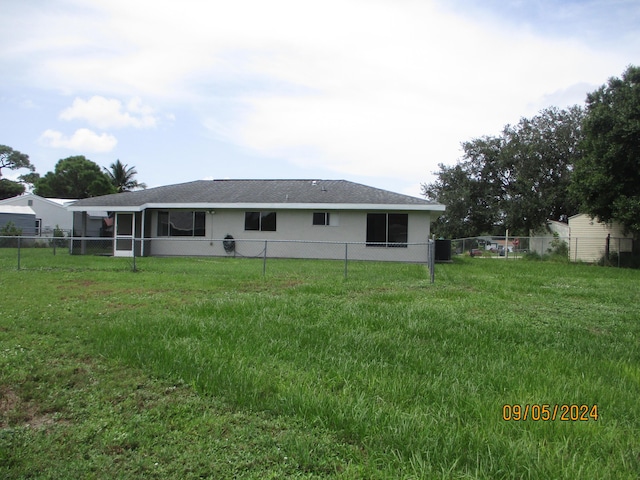 back of house with cooling unit and a yard