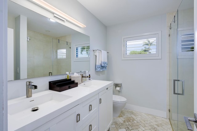 bathroom featuring vanity, toilet, and a shower with door