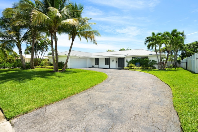 single story home featuring a garage and a front yard