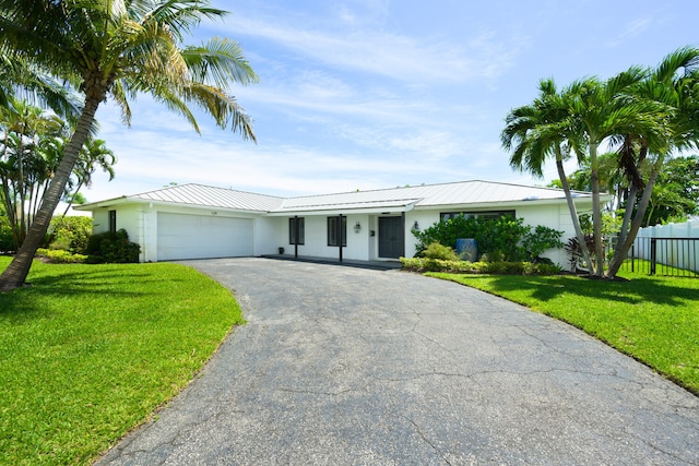 ranch-style house featuring a garage and a front yard