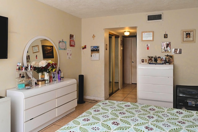 tiled bedroom featuring a textured ceiling