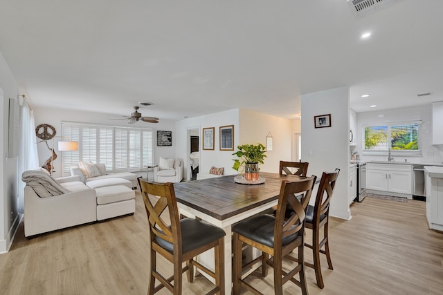 dining room featuring ceiling fan, light wood-type flooring, and sink