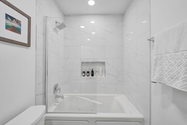 bathroom featuring tiled shower / bath combo and toilet