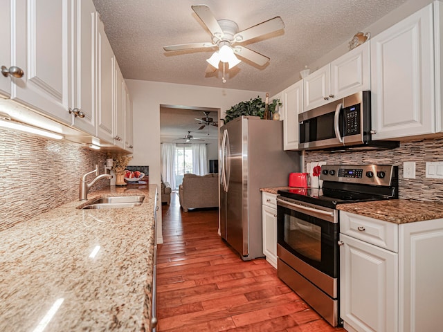 kitchen featuring white cabinetry, light hardwood / wood-style flooring, sink, ceiling fan, and appliances with stainless steel finishes