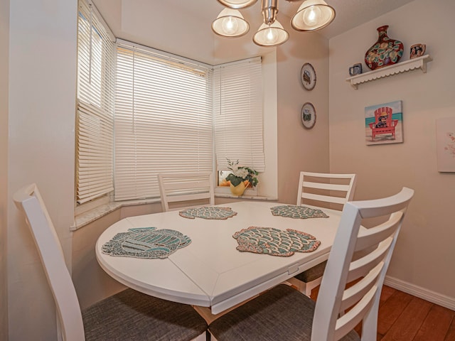 dining area featuring hardwood / wood-style flooring and an inviting chandelier