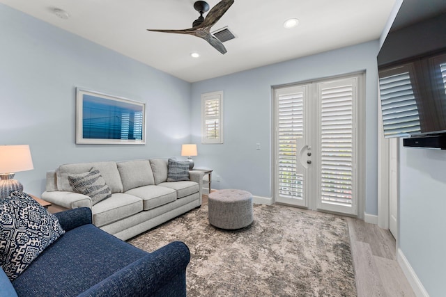 living room featuring ceiling fan and light hardwood / wood-style flooring