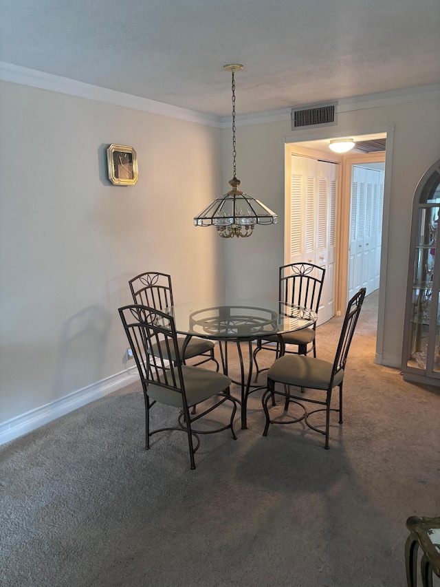 carpeted dining room with a notable chandelier and ornamental molding