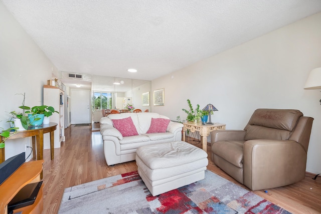 living room featuring a textured ceiling and light hardwood / wood-style floors