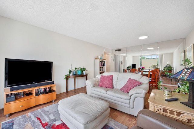 living room featuring a textured ceiling and light hardwood / wood-style floors