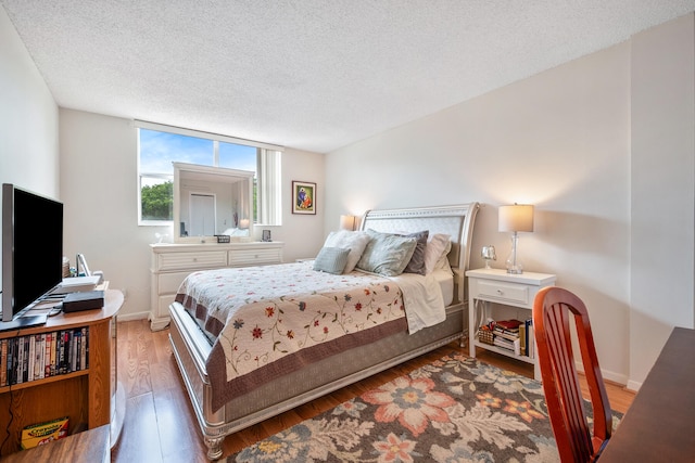 bedroom featuring dark wood-type flooring and a textured ceiling