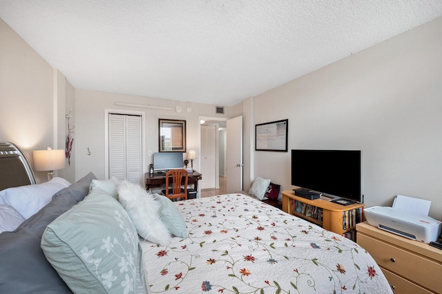 bedroom with a textured ceiling and a closet