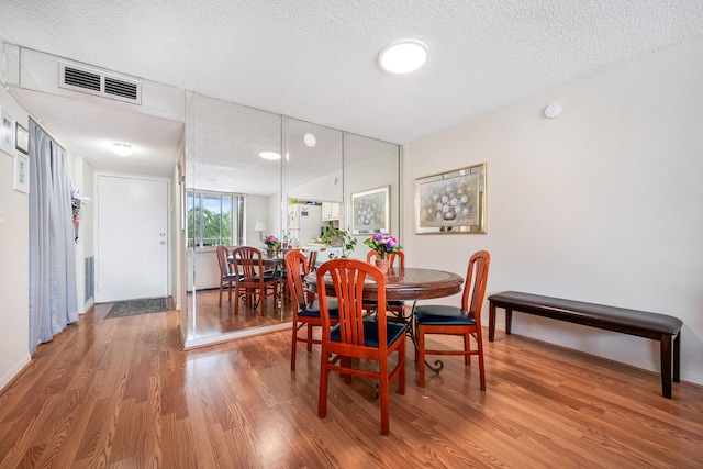 dining room featuring a textured ceiling and hardwood / wood-style flooring