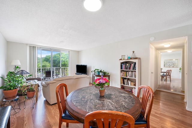 dining room featuring a textured ceiling and light hardwood / wood-style floors