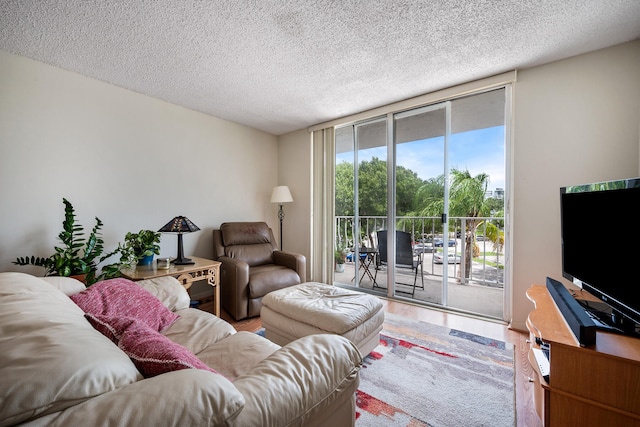 living room with hardwood / wood-style floors, a wealth of natural light, and a textured ceiling