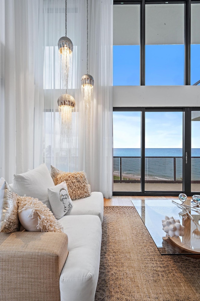 living room with a water view and a notable chandelier