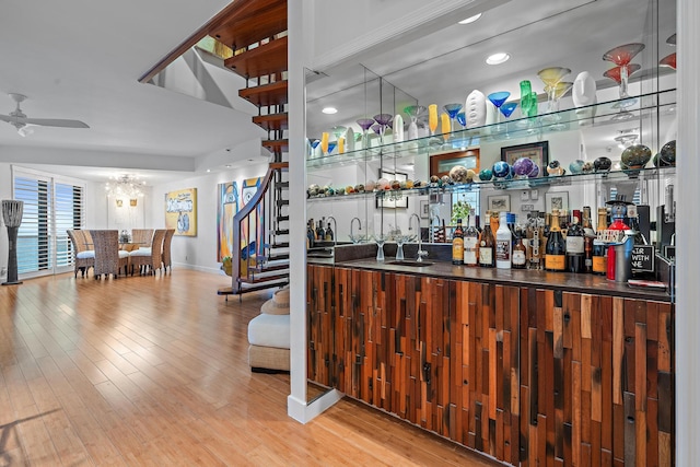 bar with ceiling fan, wood-type flooring, and sink