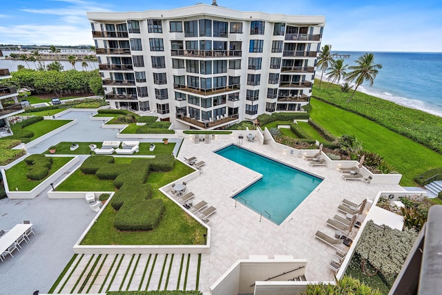 view of pool featuring a water view and a patio