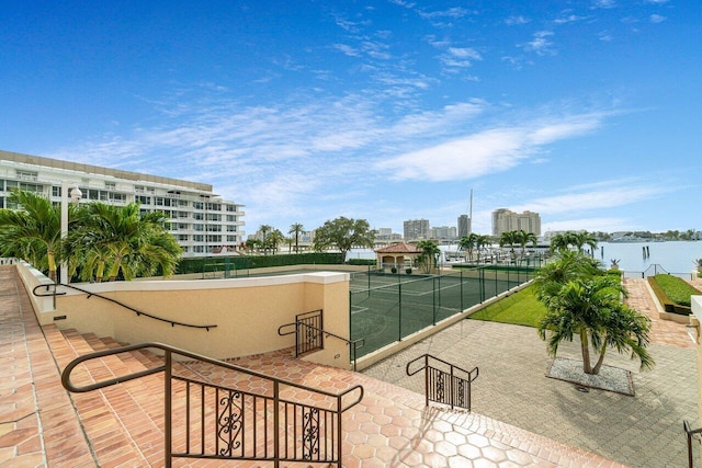 view of property's community featuring tennis court and a water view