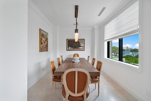 dining room featuring crown molding and light tile patterned flooring