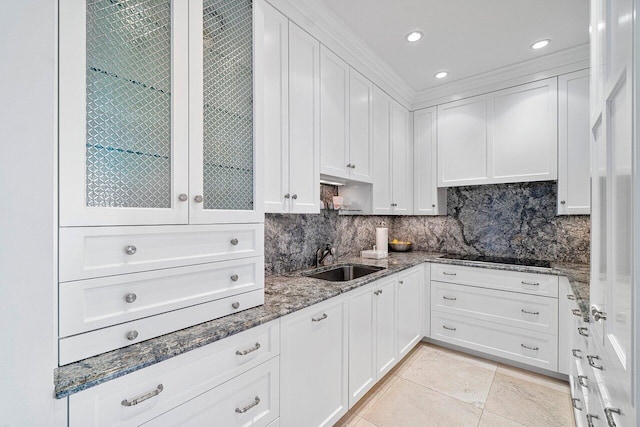 kitchen featuring white cabinets, sink, decorative backsplash, dark stone countertops, and black electric cooktop