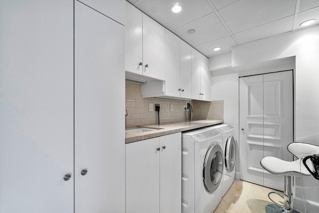 laundry area featuring cabinets, sink, washer and dryer, and light tile patterned flooring