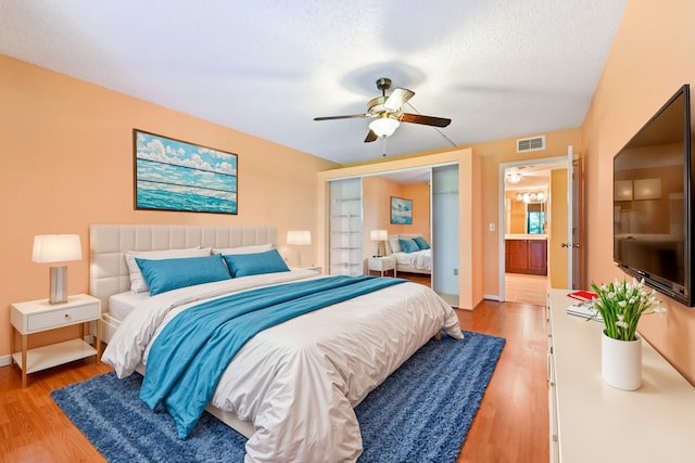 bedroom featuring wood-type flooring, a textured ceiling, a closet, and ceiling fan