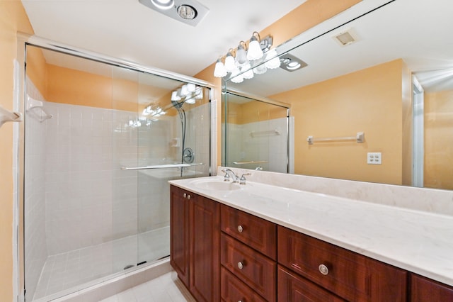 bathroom featuring tile patterned floors, vanity, and a shower with shower door