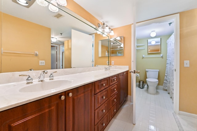 bathroom with toilet, vanity, and tile patterned floors