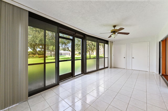 unfurnished sunroom featuring ceiling fan