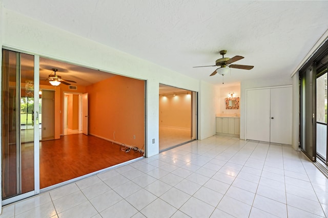 empty room featuring ceiling fan, a textured ceiling, and light hardwood / wood-style flooring