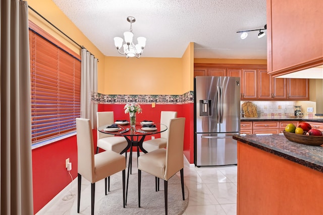 9170 SW 14th St Unit 4107, Boca Raton, FL 33428 - dining space with track lighting, a textured ceiling, and a chandelier