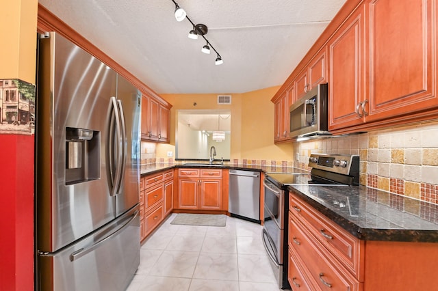 kitchen with sink, pendant lighting, decorative backsplash, light tile patterned floors, and appliances with stainless steel finishes