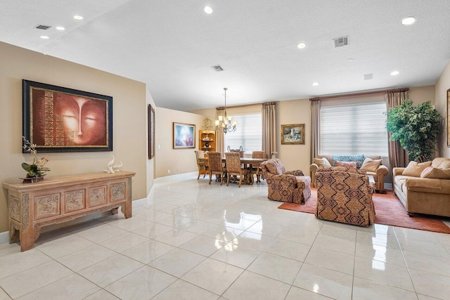 tiled living room featuring a notable chandelier, lofted ceiling, and a textured ceiling