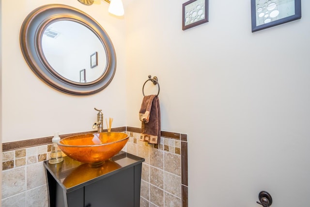 bathroom with tile walls, vanity, and decorative backsplash