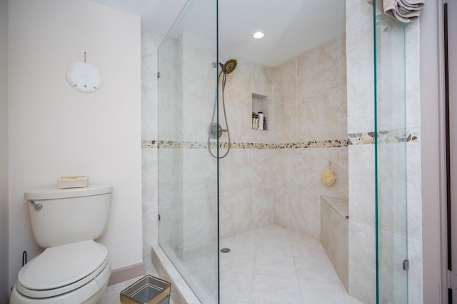 bathroom with toilet and a shower with door