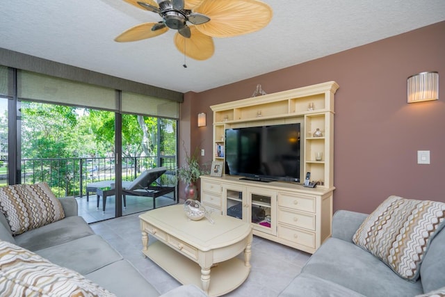 living room with ceiling fan, light tile patterned floors, and a textured ceiling