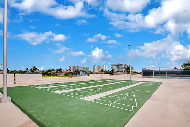 view of home's community featuring tennis court