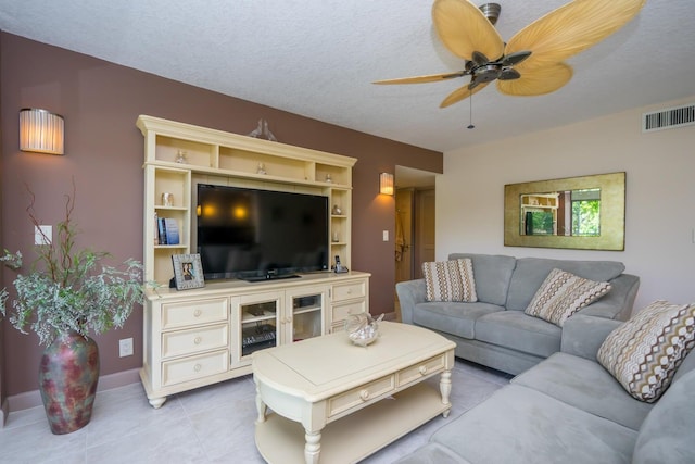 living room with a textured ceiling, light tile patterned flooring, and ceiling fan