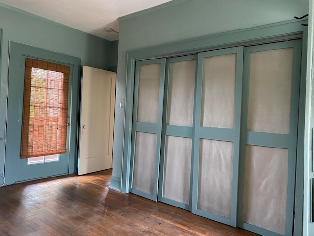 unfurnished bedroom featuring dark hardwood / wood-style floors and a closet