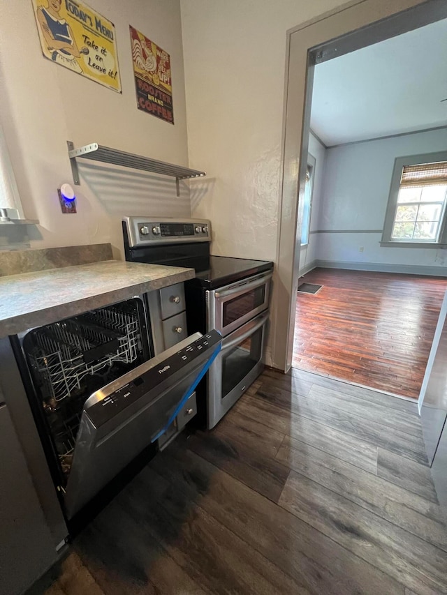 kitchen with dishwasher, dark wood-type flooring, and stainless steel range with electric stovetop