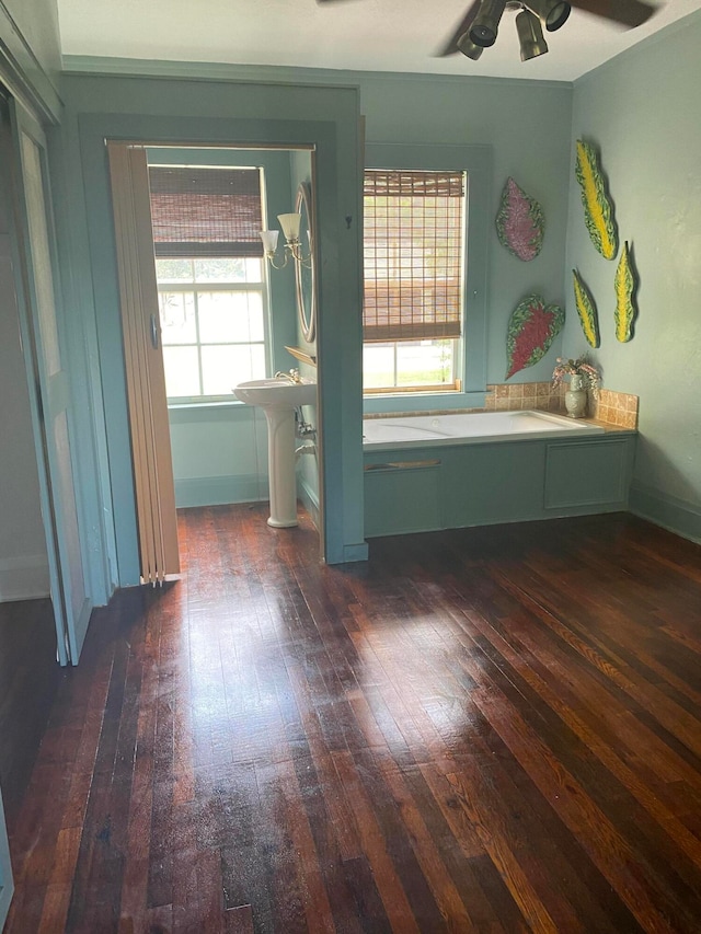 unfurnished bedroom with ceiling fan, dark wood-type flooring, and multiple windows