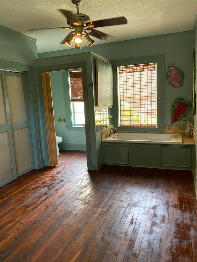 empty room with wood-type flooring, a textured ceiling, and ceiling fan