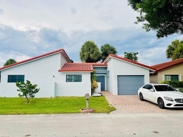 mediterranean / spanish house featuring a garage and a front lawn