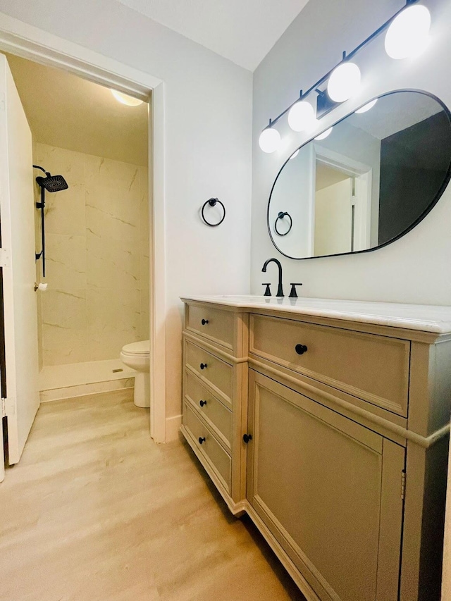 bathroom with a shower, toilet, vanity, and wood-type flooring