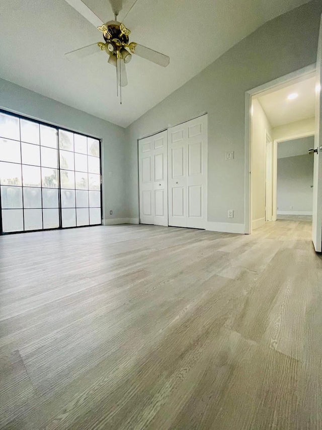 unfurnished bedroom with light carpet, lofted ceiling, ceiling fan, and a closet