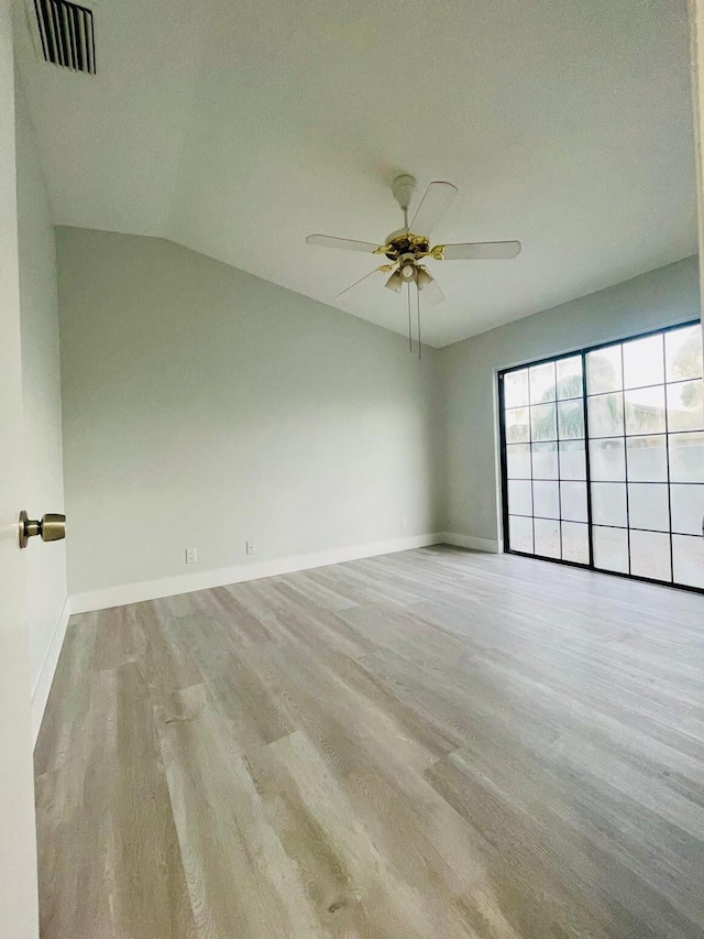 empty room featuring lofted ceiling, light hardwood / wood-style floors, ceiling fan, and a textured ceiling